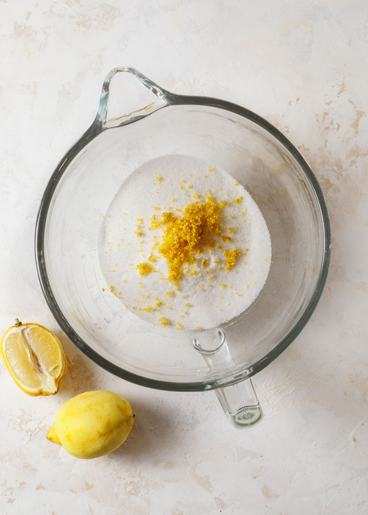 Lemon zest in a bowl with granulated sugar