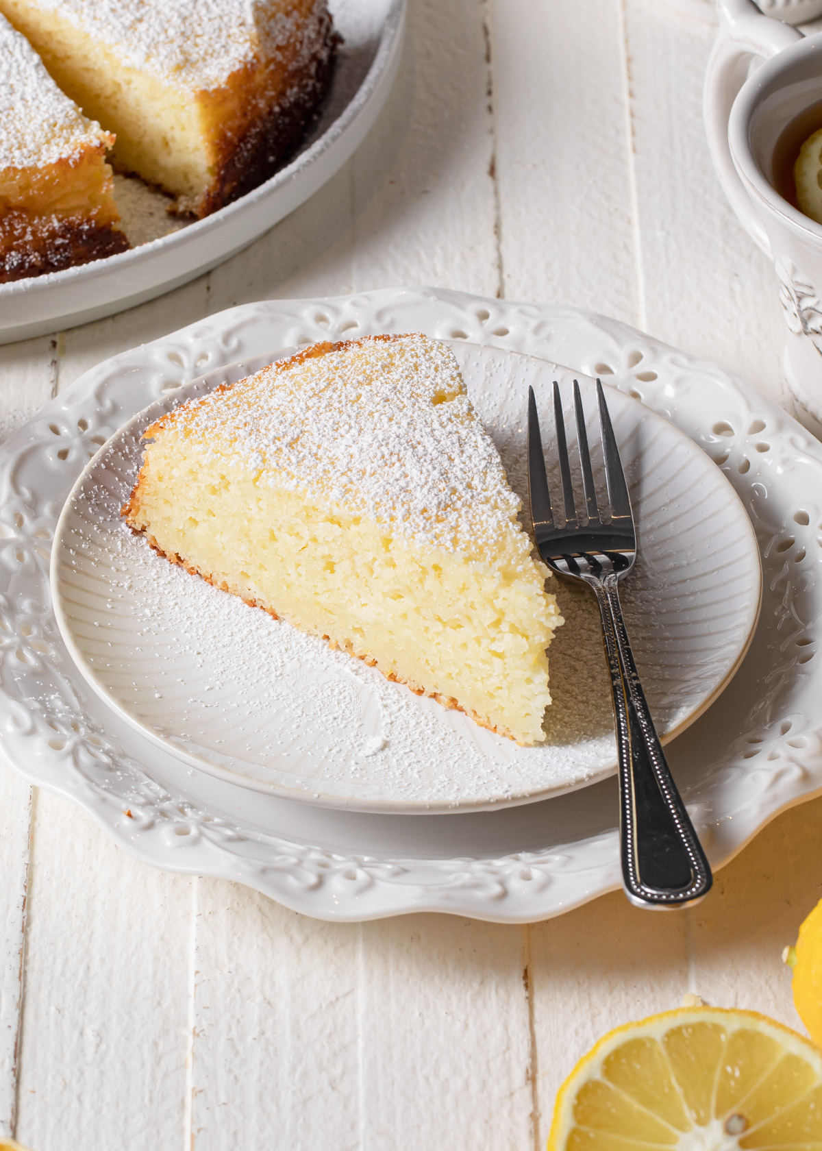 A thick slice of lemon ricotta cake set on a white plate