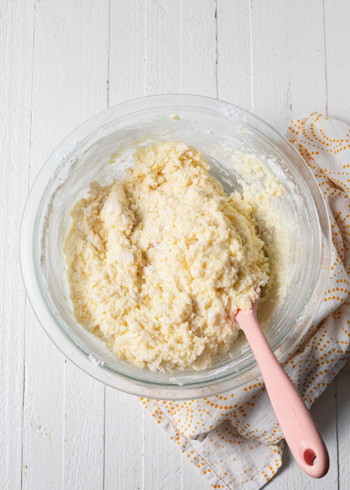 Mixing up ricotta cake batter in a glass bowl