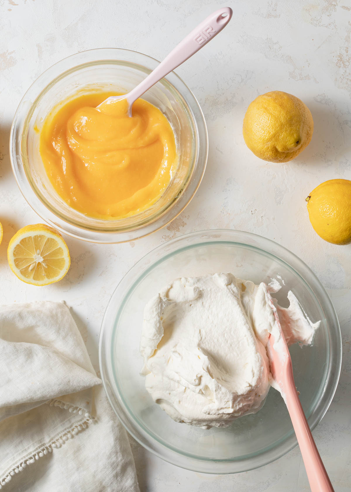 Lemon curd and whipped cream in glass bowls