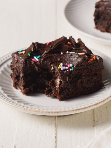 A super rich and fudgy cocoa brownie on a white plate.