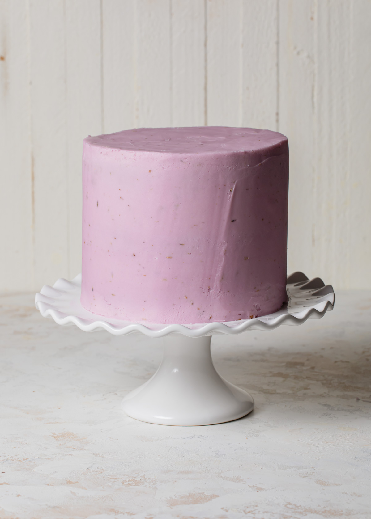 A smoothly iced lavender layer cake with purple frosting