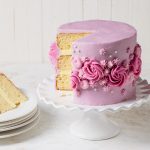 Lavender cake with layers of lemon filling and piped buttercream flowers