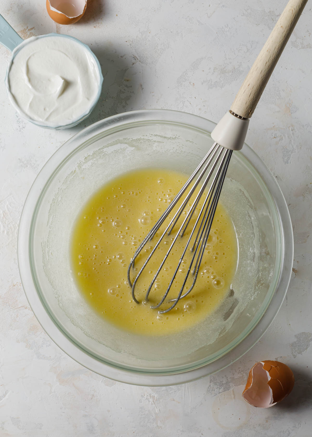 Whisking eggs, sugar, and oil in a yogurt cake