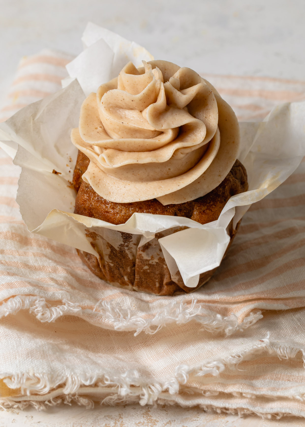 Swirls of cinnamon buttercream on top of a cupcake