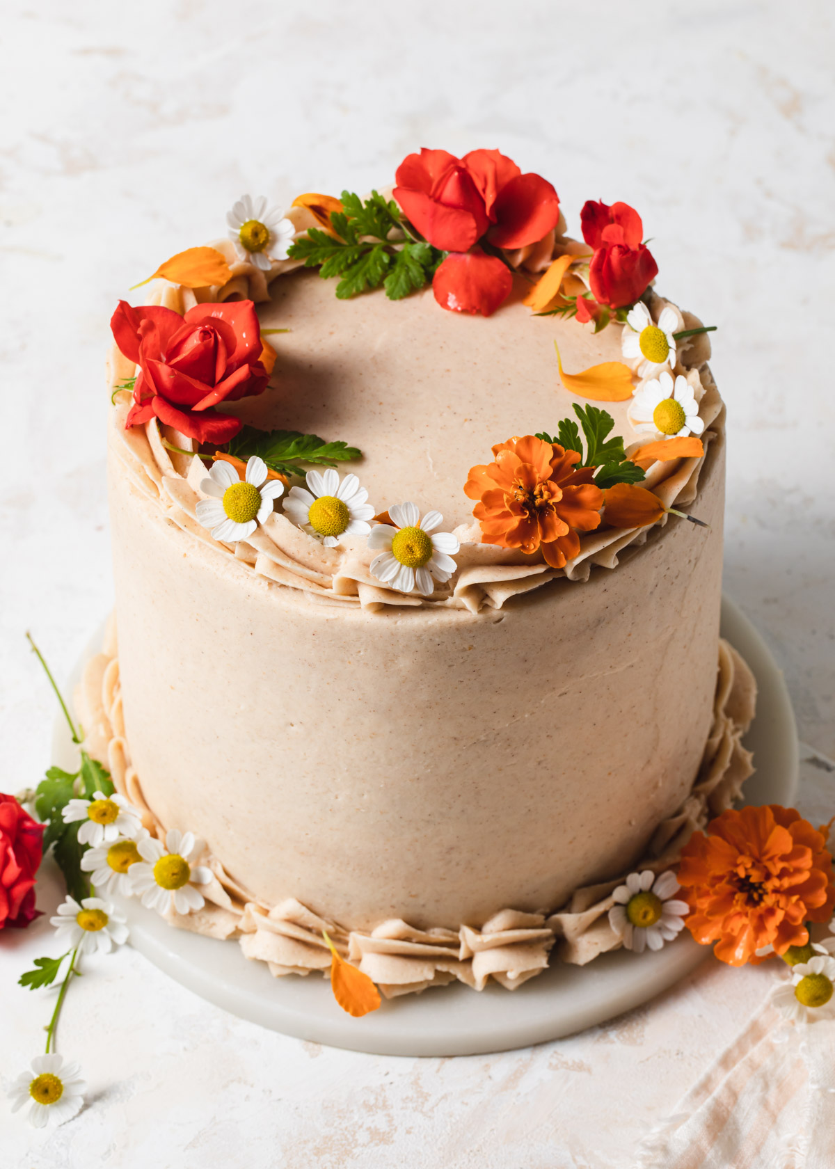 A frosted pear cake decorate with fresh flowers