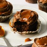 a bite take out of a chocolate cupcake with caramel on top