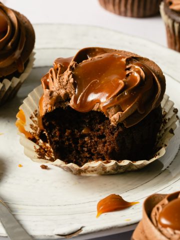 a bite take out of a chocolate cupcake with caramel on top