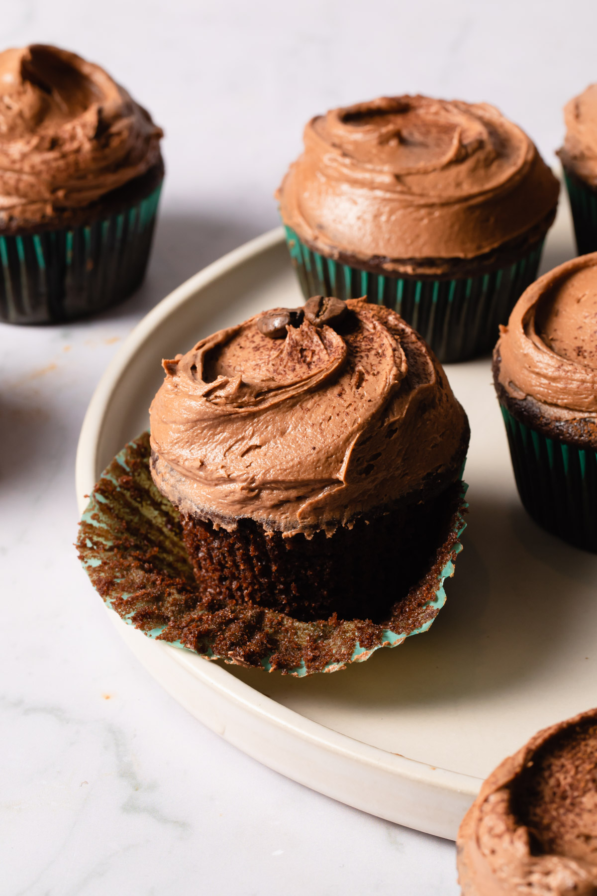 Chocolate cupcakes with mocha frosting on a white plate