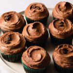 A platter of mocha cupcakes with swirls of frosting on top