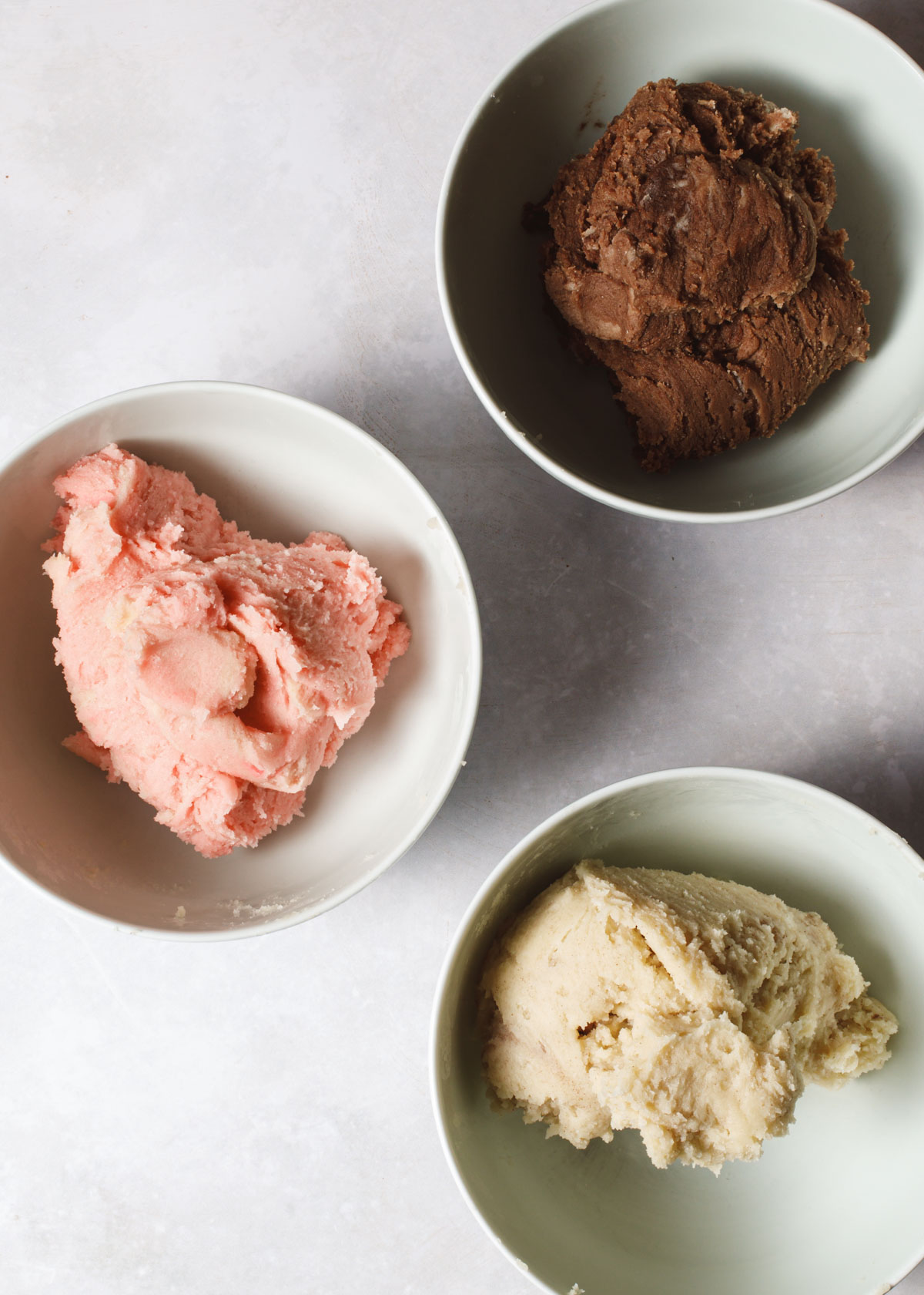 three bowls of different flavor cookie dough