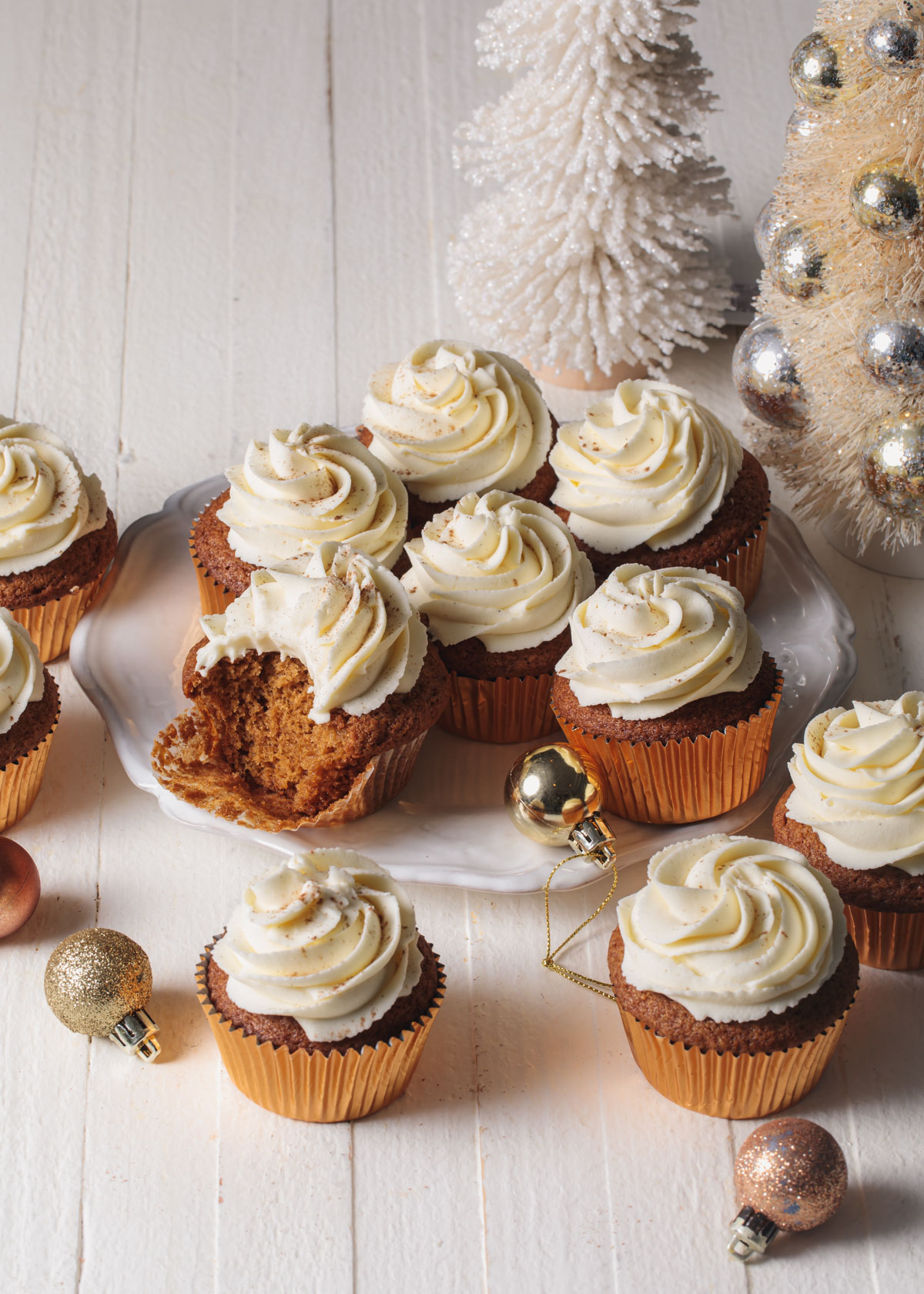 A platter of gingerbread cupcakes with white chocolate frosting