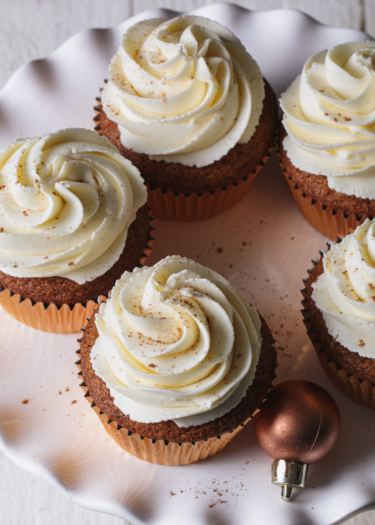 Whipped white chocolate ganache frosting swirled on top of cupcakes.