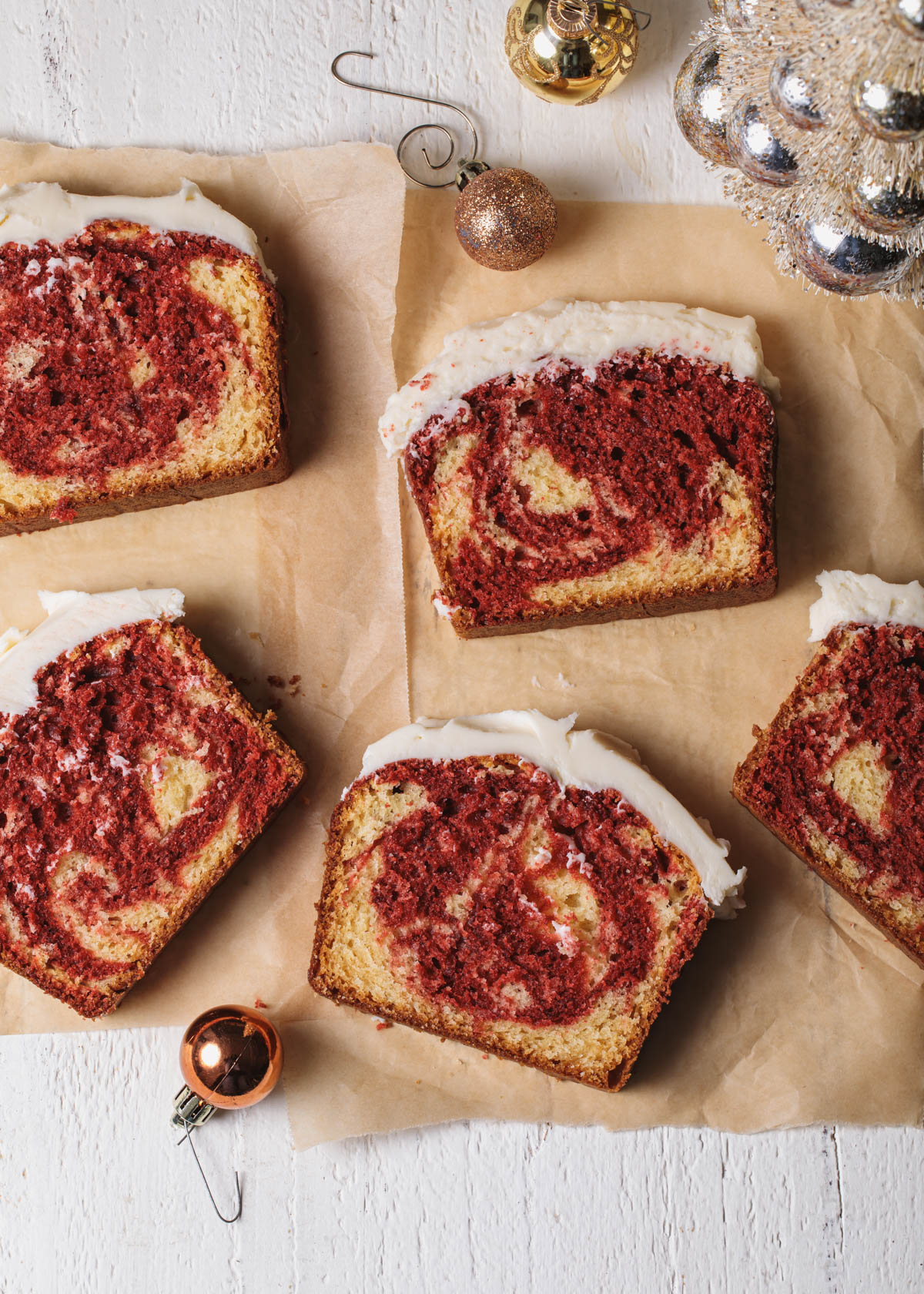 An overhead view of slices of red velvet marble cake with vanilla icing