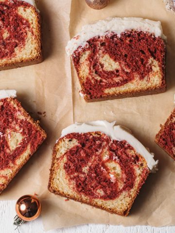 An overhead view of slices of red velvet marble cake with vanilla icing