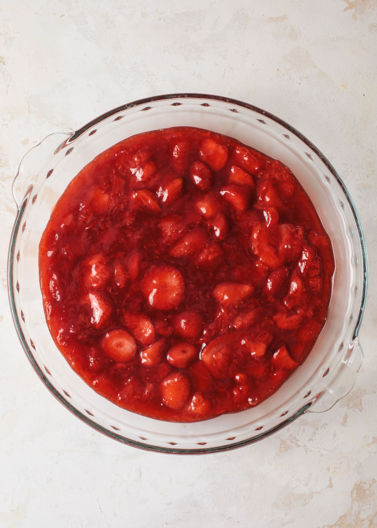 Strawberry cake filling cooling in a glass dish