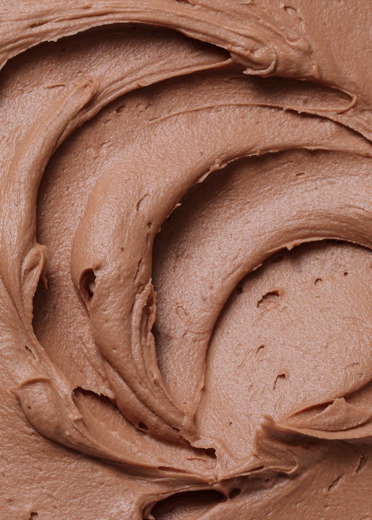 A close-up of chocolate frosting swirls