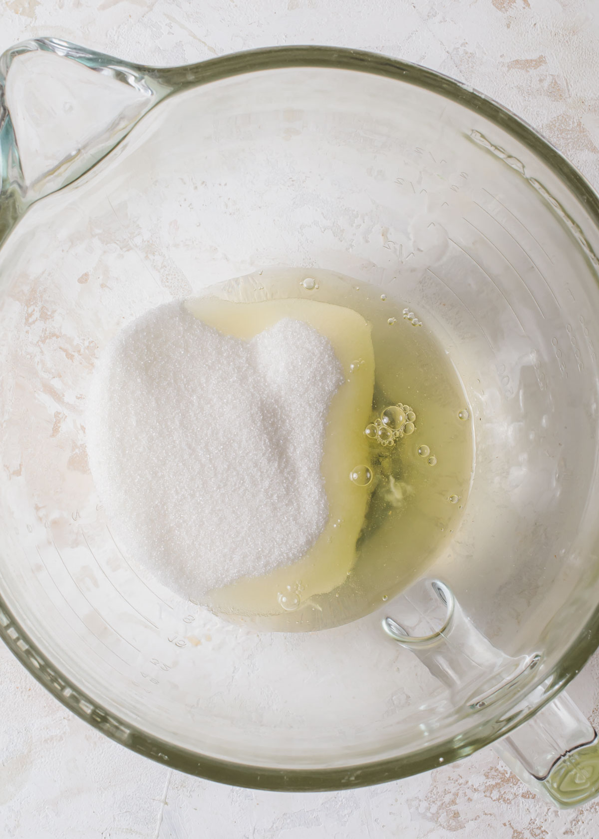 Egg whites and granulated sugar in a mixing bowl